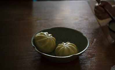 Two buns in a black china bowl