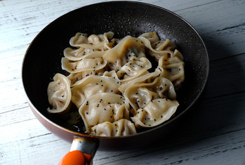 A plate of fried dumplings sprinkled with sesame