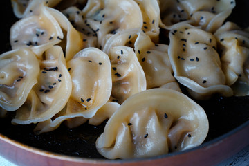 A plate of fried dumplings sprinkled with sesame
