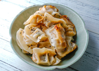 A plate of fried dumplings sprinkled with sesame