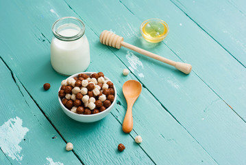 breakfast cereal with milk, honey on blue wood table