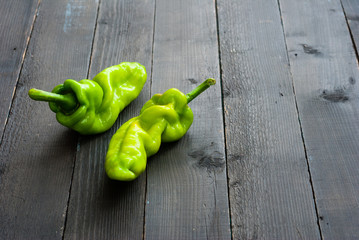 two pepper fruits on black wooden