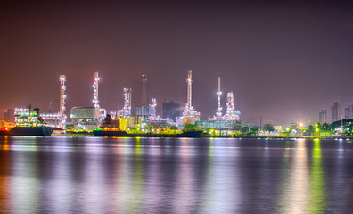 Beautiful reflection of Oil refineries located along the river with dark sky background-Image