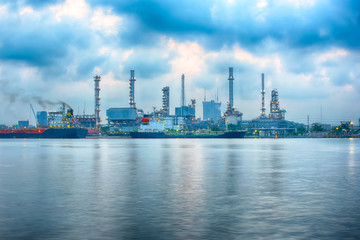 Beautiful reflection of Oil refineries located along the river with dark clouds background-Image