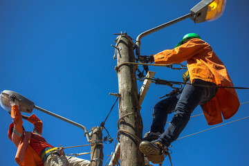 Lineworkers doing maintenance of street lamps in Africa