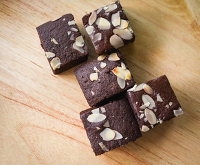 brownies cake on the table - chocolate cake slice with nut on wooden background top view