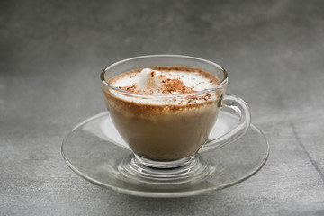 hot dry cappuccino in a cup on a grey background 