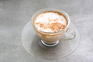 hot dry cappuccino in a cup on a grey background 