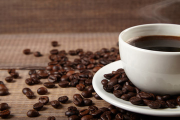 cup of coffee and beans on wooden background