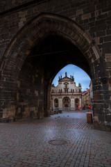 Looking through an arch on Prague's Charles Bridge at twilight