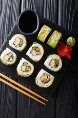 set of Japanese rolls of green dragon with avocado, omelet, sesame and cucumber closeup on a plate. Vertical top view