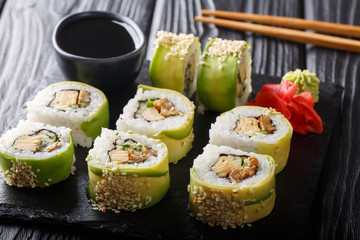 Green japanese roll with avocado, tamago omelette, sesame and cucumber closeup on a plate. horizontal