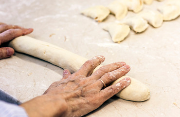 Female hands kneading making dough for dumplings .