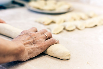Female hands kneading making dough for dumplings .