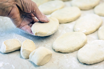 Fototapeta na wymiar Woman hand making tasty fried patties or pies in kitchen.