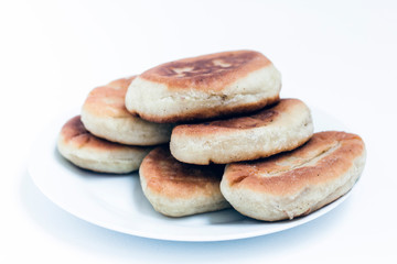 Fried cakes with potato and beans on white table background .