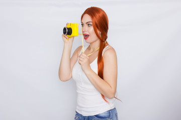 Redhead woman making photot and looking at yellow camera