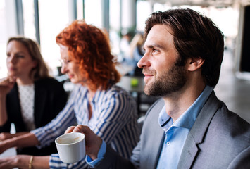 A group of young business people sitting in an office, working.