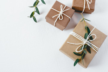 Craft gift boxes on white wooden background. Copy space for text. Eco concept