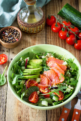 Diet menu, Vegan food. Healthy salad with quinoa, arugula, Tomatoes, Salmon and Avocado on rustic table. Free space for your text.