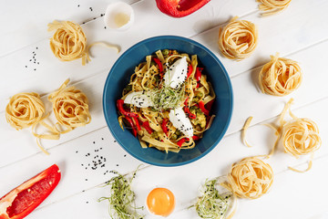 Italian Egg Pasta Tagliatelle and Cream Cheese Top View. Homemade Spaghetti in Bowl on White Table Flat Lay. Spagetti with Ingredients Above for Recipe. Cooked Wheat Rigatoni. Tasty Restaurant Diet