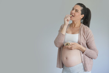 Pregnant woman eating cereals, isolated