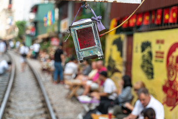 Railway sign bulb with people drink coffee on background waiting for train to arrive on railway road in Hanoi, Vietnam.