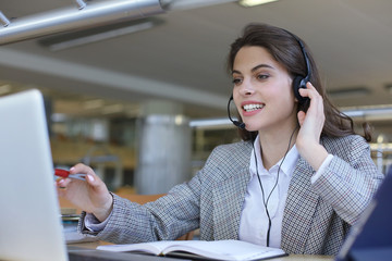 Woman customer support operator with headset and smiling.