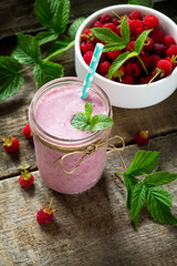 Raspberry fruit Yogurt smoothie or milk shake in glass jar on a wooden rustic table. Natural detox, fruit dessert, healthy dieting concept.