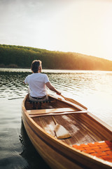 Fototapeta na wymiar Canoeist paddling the wooden boat