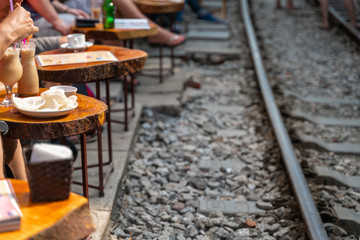 Fototapeta na wymiar Railway cafe. People drink coffee or walking on railways waiting for train to arrive on railway road in Hanoi, Vietnam.