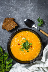 Red lentil soup on black top view.