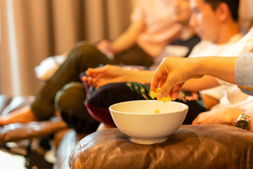 Fototapeta na wymiar Woman hands taking popcorn from bowl watching movie with friend.
