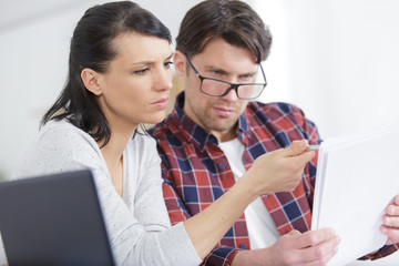 couple sitting on couch calculating bills