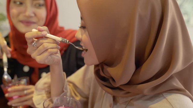 hijab women enjoy sweet drink when breaking fast together at home