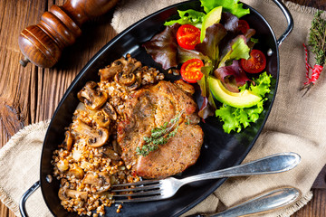 Pork steak with mushrooms and buckwheat groats and mango salad