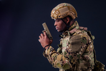 Fototapeta premium american man in camouflage suit aiming with a pistol