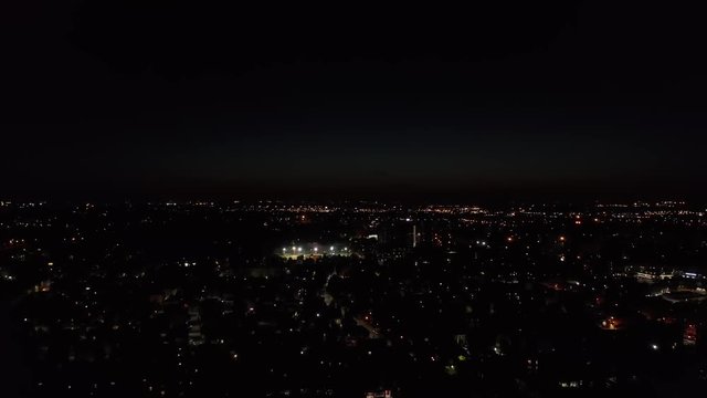 Aerial &ndash; Cinematic spotlight shoot around a football stadium in the night