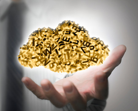 Big data and cloud computing concept. Businessman hand holding yellow cloud of 3d letters and numbers, self-illuminated.