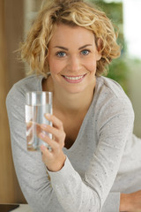 young woman holding glass of water