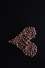 set of raw peanuts making design on a dark wooden table