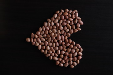 set of raw peanuts making design on a dark wooden table