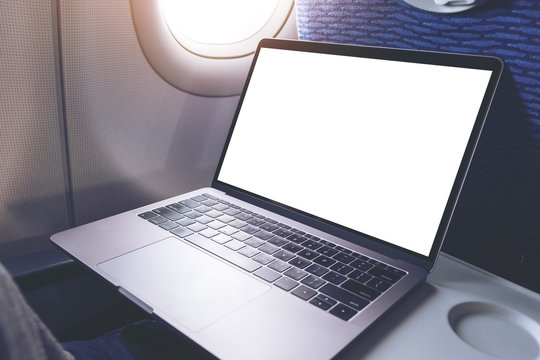 Mockup image of laptop computer with blank white desktop screen in the cabin