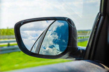 Naklejka premium Landscape in the sideview mirror of a car