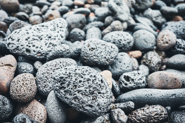 Natural background made of volcanic rocks and pebbles, selective focus, color toning applied.