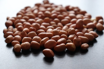 set of raw peanuts making design on a dark wooden table