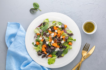 Baked beet and carrot salad with cheese on grey background, top view 