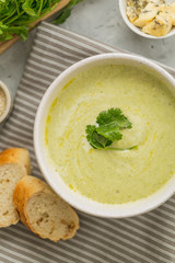 Fresh made broccoli cream soup in a white bowl, top view