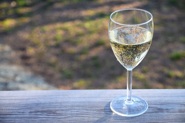 Glass of white wine on table in garden on a summer evening in Sweden