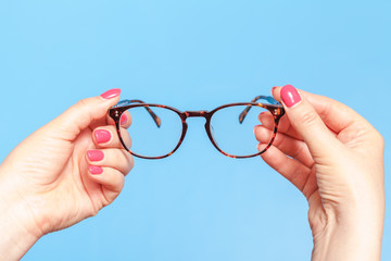 modern reading glasses. Woman is taking  optics spectacles
